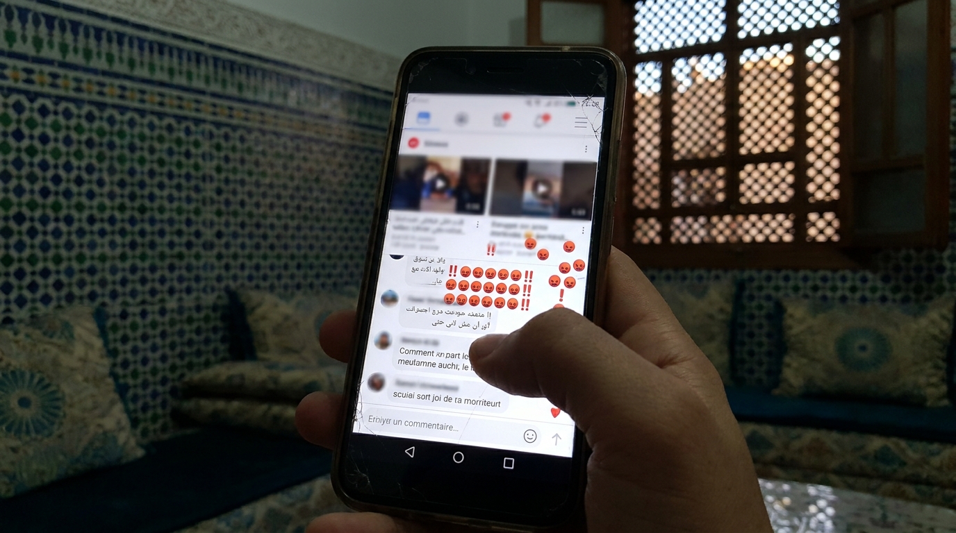 Un écran de smartphone affichant une vidéo choquante sur les réseaux sociaux, avec des commentaires d'indignation.